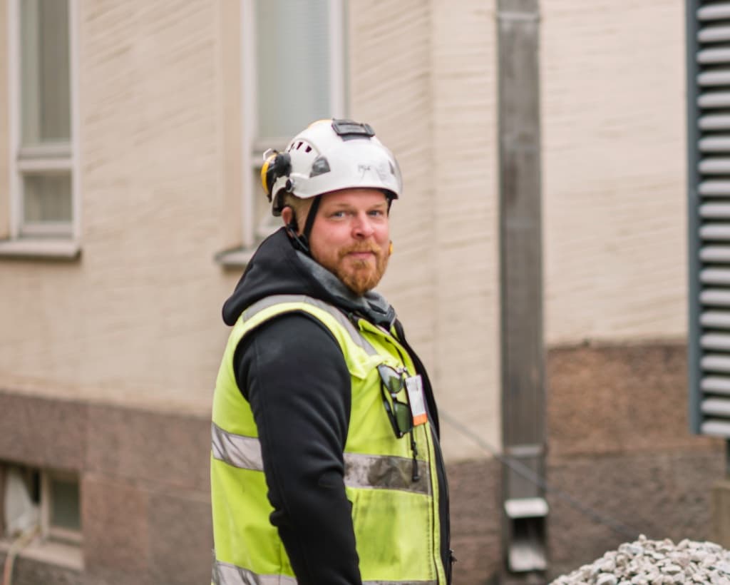 Ville Sainio työmaalla suojakypärä ja huomioliivi päällään